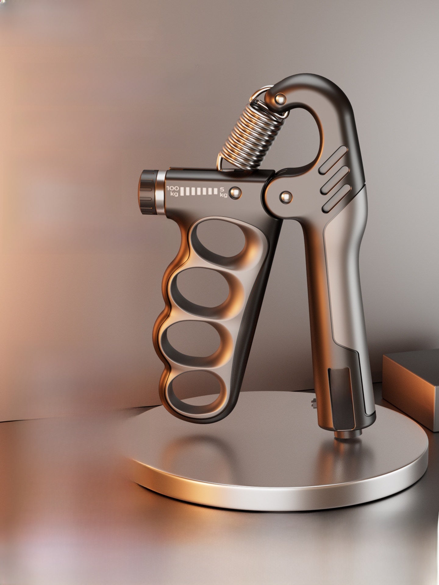 Grip strength device by FitGearMonarch on a metal stand, featuring a spring coil, hand grips, and gray finish.